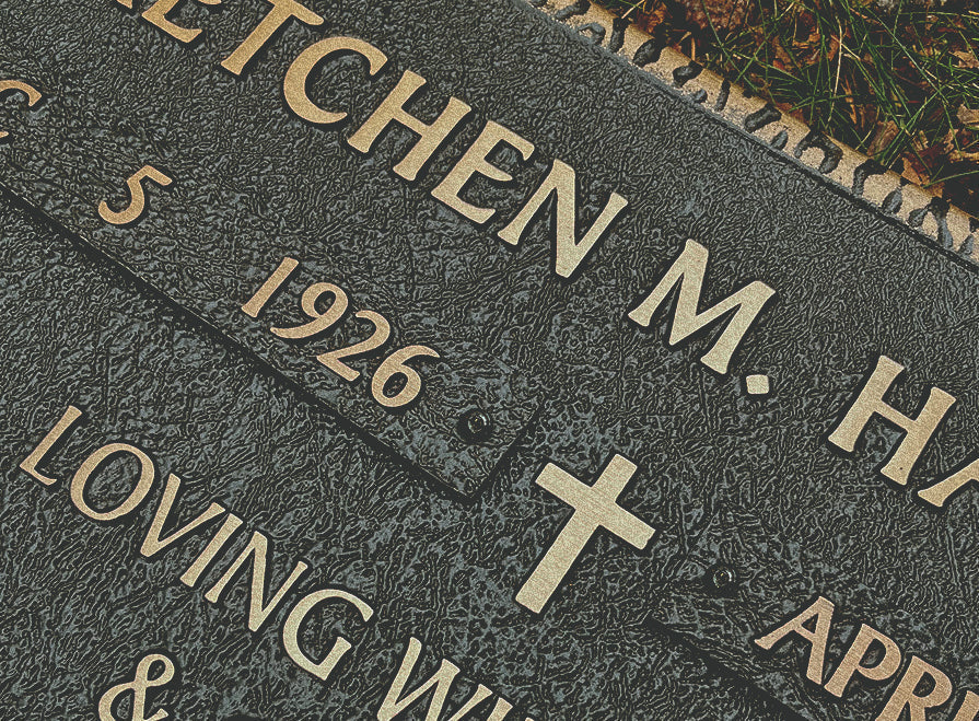 A close up image of a date ribbon shown on a larger memorial plaque. Plaque shown in statuary bronze finish with polished raised text.